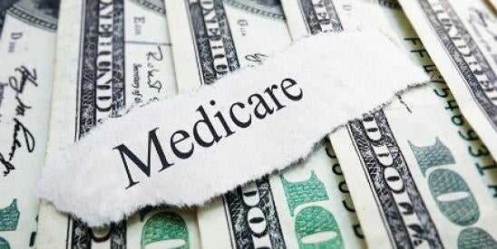 medicare funding depicted as torn off note on a stack of $100 bills