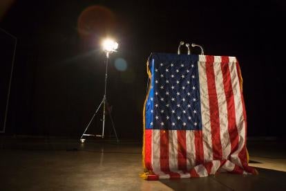 American flag, podium, microphone, spotlight