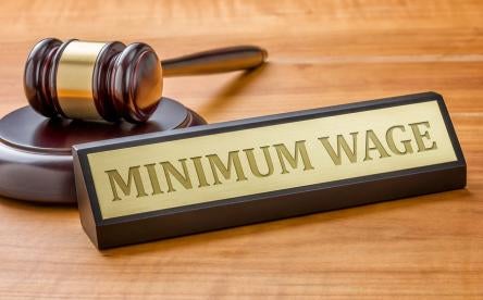 minimum wage lawsuit depicted with a desktop title card and resting gavel