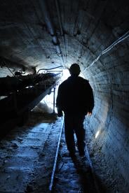 miner in a dark tunnel impacted by MSHA regulations