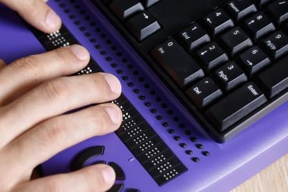 Fingers on a Braille outfitted keyboard