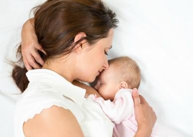 healthcare employee breastfeeding a newborn child