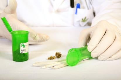 professional in a lab coat and gloves preparing a medicinal marijuana prescription 