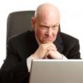 Angry businessman using laptop
