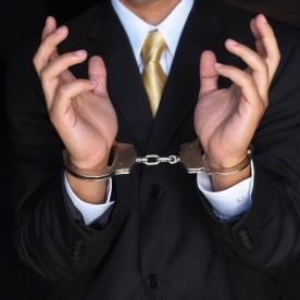 businessman in cuffs, sec, bribery charges