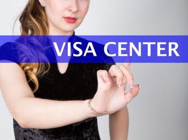 woman clicking on a screen in front of her with a Visa Center Blue banner