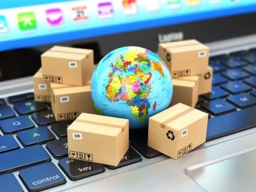 a globe surrounded by boxes on a keyboard depicting international trade