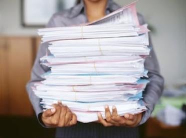 professional woman with a stack of corporate paperwork