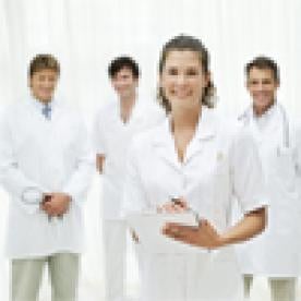 a smiling female nurse with a group of other health care professionals including doctors