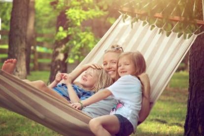 happy mom and kids in a hammock enjoying family leave 