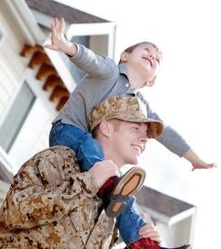 smiling military man with his happy son on his shoulders