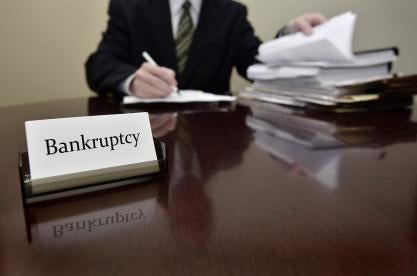 Bankruptcy on a White Card with Man Signing Paperwork