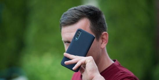 man hiding behind cellphone fears robocalls