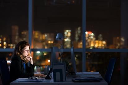 female lawyer working late into the night at her BigLaw office