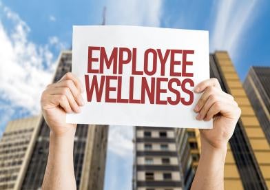 employee wellness sign held by employee receiving an individual coverage health reimbursement arrangement