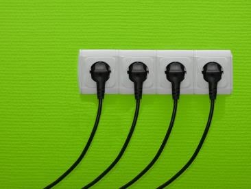 a row of four electric plugs in the wall