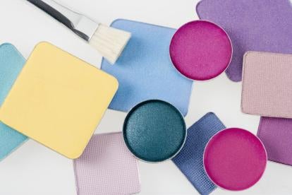 various colors of makeup palettes and a brush