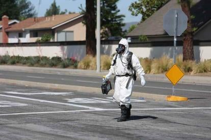 a small man in a big suit designed to protect him from Asbestos in the US